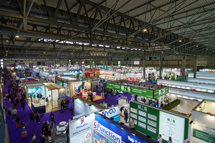 Visitors walking through a large trade exhibition hall
